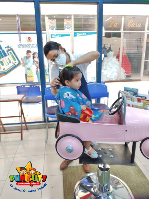 niña sentada recibiendo su corte de cabello en peluqueria fun cuts nicaragua